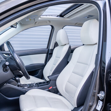 Leather interior design, car passenger and driver seats, clean, wide angle view, white perforated leather