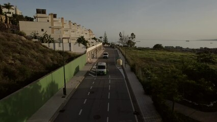Camper vans driving along the coastal residential area of Malaga, Spain, embodying the spirit of travel, exploration, and leisurely pursuits during free time.