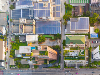 Several tall buildings with recreation areas and swimming pools on the roof, next to a building with solar panels and the redesign of the car street area, aerial top view