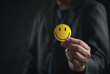 Man holding a smiley face emoticon.concept happy digital marketing customer service product client feedback - 793610743