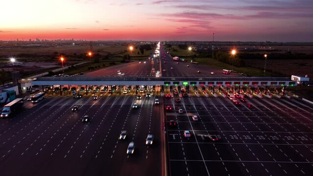 Cars pass through Hudson toll booth by Buenos Aires, static timelapse at dusk