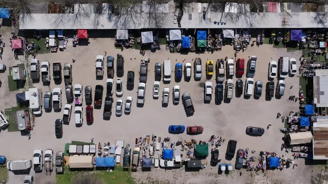 Top down aerial footage of cars in a flea market parking lot in Houston, Texas.