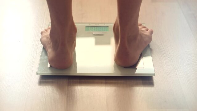 Man legs step on bathroom scale . Man on scales measure weight	
