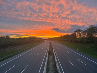 German highway A2 from above, bright red sunset sky panorama with fleece colorful clouds. Near...