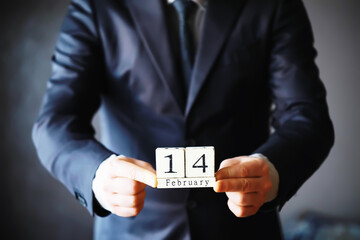 Man's hands close up with 14 February date calendar. Saint Valentine's celebration concept. Holiday...