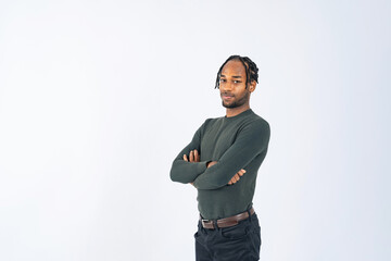 A black man stands with his arms crossed in front of a white background