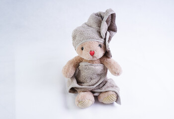 A stuffed bunny toy in a bath towel on its head