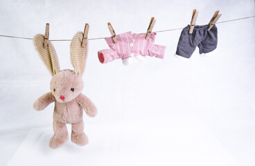 A stuffed hare toy hangs clothes to dry