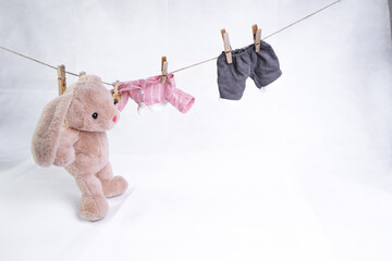 A stuffed hare toy hangs clothes to dry
