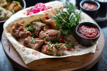 Juicy grilled kebabs on flatbread with fresh herbs and pomegranate. A delicious fusion of flavors,...
