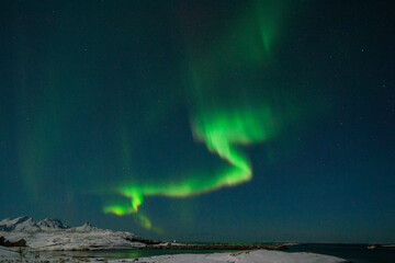 Wide angle shot of the aurora borealis, the northern lights, over the Norwegian islands near Mjelle on a winter evening.