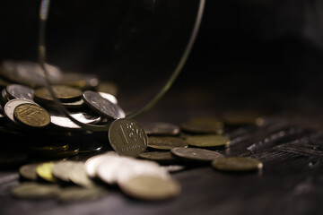 Russian rubles and metal coins inside a glass jar close-up on black blurred background
