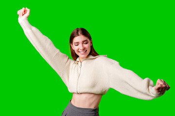 Joyful Young Woman Celebrates With Arms Raised Against Green Screen