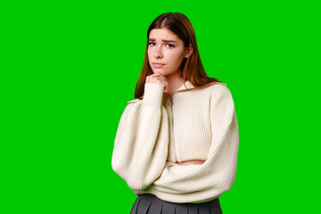 Young Woman Deep in Thought Against a Green Screen Background