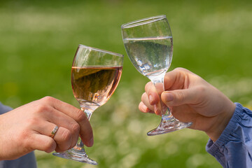 .Male and female hands hold glasses of wine and water. The couple spends time together. Love, holiday.