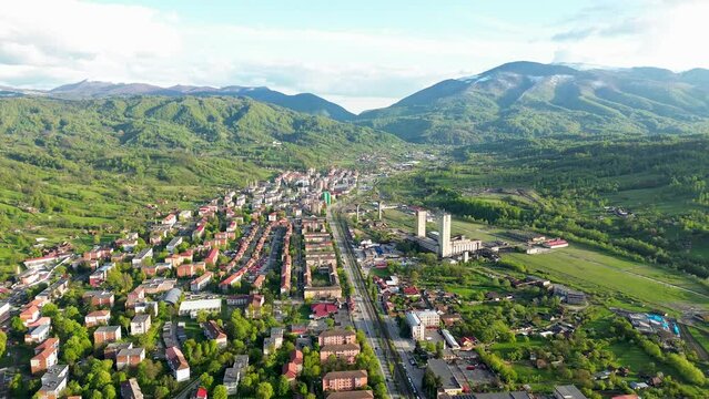 4k cinematic aerial drone footage featuring a beautiful city in the big carpathians with the mountains in the backround filmed with mini 3 pro.