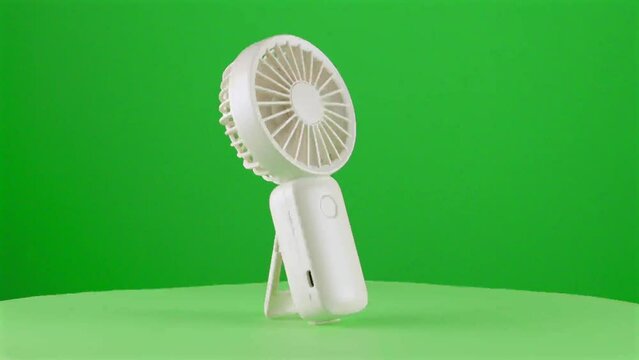 Turn on Handy fan electric hand mobile ventilator handyfan portable heat hot in a turntable with green screen for background removal 3d