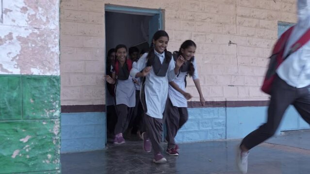 Group of rural indian school students running out of classroom, Education in india. running home.