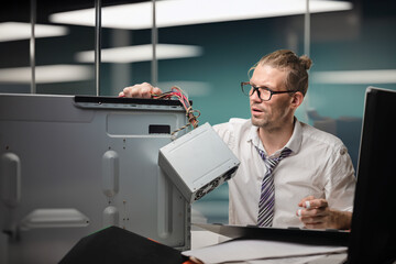Portrait of sad minded man unable to repair his broken office pc, Deskside IT magic: Employee embraces DIY computer repair for quick solutions