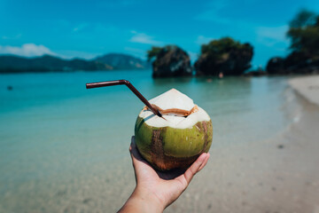 coconut in hand at the beach on a summer day