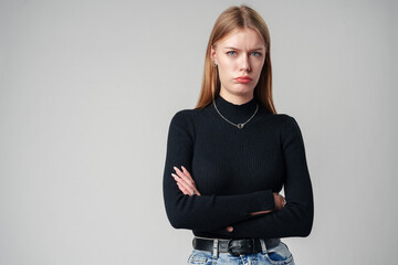 Young Woman Wearing Black Top and Jeans against gray background