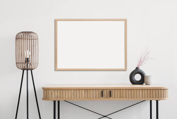 Obraz premium Empty horizontal frame mockup in modern minimalist interior with plant in trendy vase on white wall background. Template for artwork, painting, photo or poster