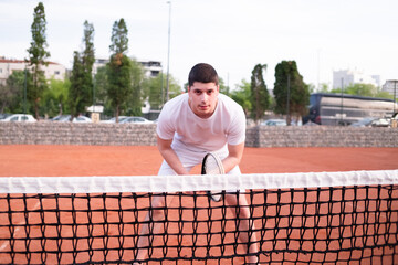 Young tennis player playing tennis by the net