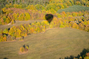 Shadow of hot air balloon over autumn colorfull forrest in south moravia, Czech republic, Europe