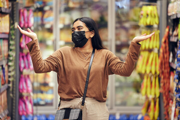 Woman, face mask and grocery shopping with choice, decision or confused for market price increase...
