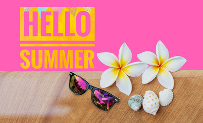 Hello summer banner on pink background with fresh Plumeria flower and sunglasses, summer season background idea