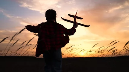 Fotobehang child kid girl with toy pilot runs into sunset dream flying flight, child with toy airplane, sunset playtime, running through field, kid's adventure, outdoor childhood activity, toy glider in nature © DREAM INSPIRATION