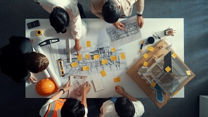 Top down view of skilled engineer team compare between blueprint and house plan. Aerial view of...