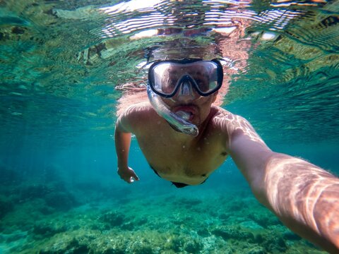 Self view of man diving on clear water