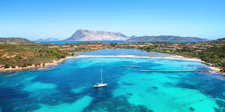 Sailing boat in Salina bamba beach aerial drone view, Sardinia