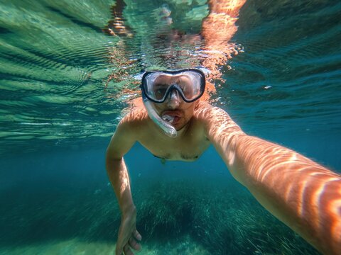 Self view of man diving on clear water
