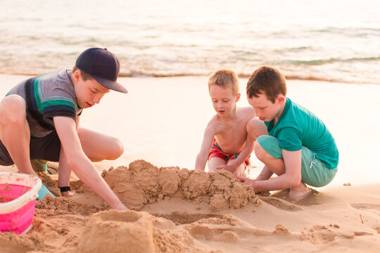 3 brothers building a sand castle