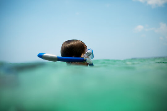 Child snorkeling in clear waters, ocean exploration