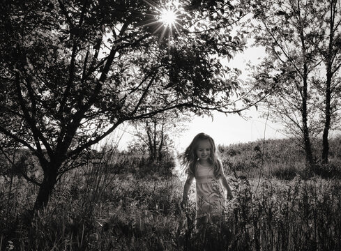 Happy young girl walking through sunny field
