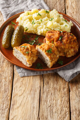 Holandsky rizek Czech Dutch or Holland Schnitzel is a breaded and fried ground pork schnitzel with grated cheese served with mashed potatoes closeup on the plate on the table. Vertical