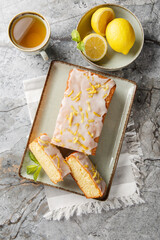 Lemon Drizzle Cake has a crunchy sugar glaze that crystallizes on top closeup on the plate on the table. Vertical top view from above