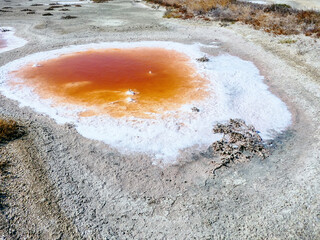 Subsidence funnels on salt marsh are filled with lakes of diverse colors. Red color caused by...