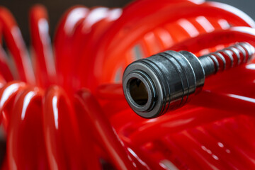 An orange air hose with an hose coupling , closeup. Detail of air compressor hose and pistol