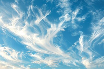 Wispy clouds floating peacefully against a backdrop of clear blue sky - obrazy, fototapety, plakaty