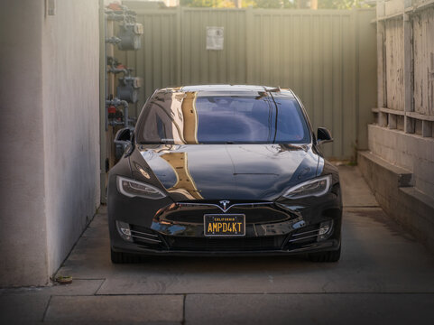 LOS ANGELES - April 7, 2024: Black Tesla Model S electric car parked in driveway outside of building. Front view.