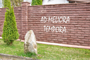 Ad meliora tempora it means in Latin may we meet in better times writing on a red brick fence - obrazy, fototapety, plakaty