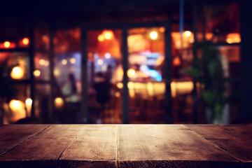 image of wooden table in front of abstract blurred background of restaurant lights - 793670748
