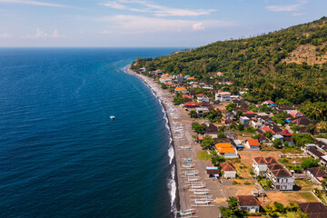 Amed, Bali: Aerial view of the Amed village with its beach lined with traditional fishing boat, the Jukung, and hotel and guesthouse in Bali northeast coast in Indonesia