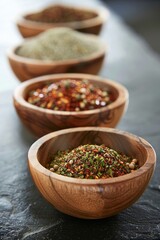 Artisanal selection of gourmet spices and seasonings displayed in wooden bowls on dark background