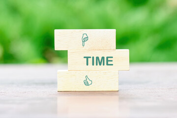 Time Concept TIME TEXT on wooden blocks in front of a green background of green leaves out of focus - obrazy, fototapety, plakaty