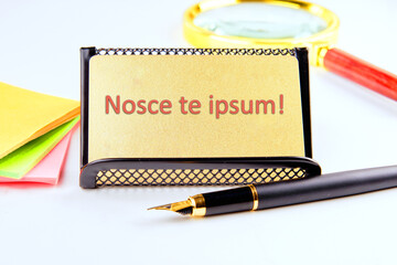 Latin proverb NOSCE TE IPSUM (know yourself) on a gold business card with highlighted text - obrazy, fototapety, plakaty